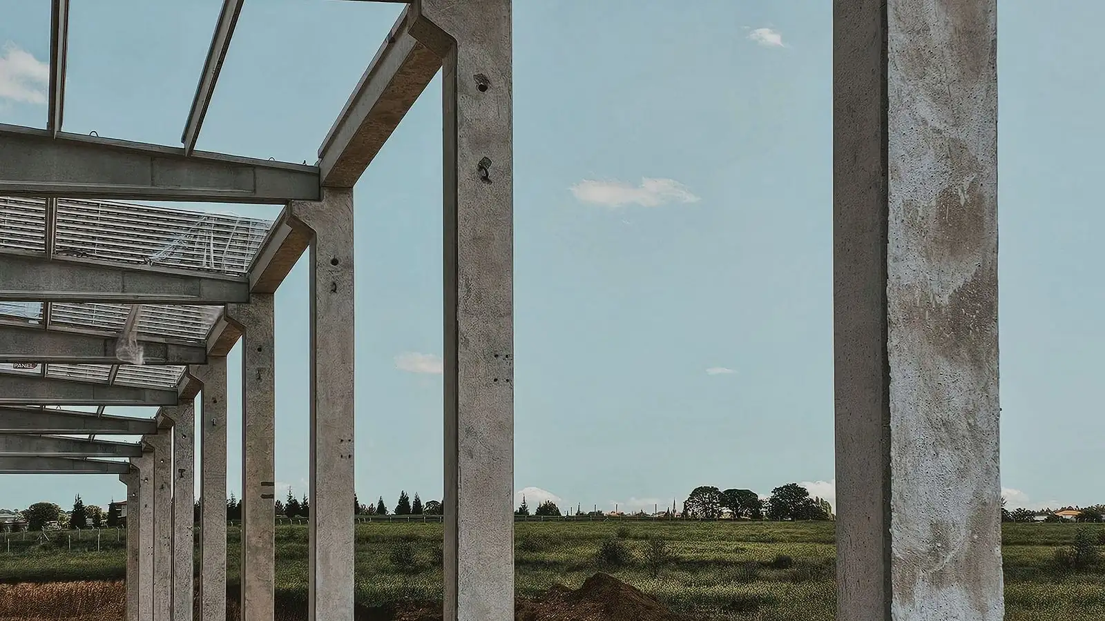 Pórtico de concreto de um galpão em construção, com pilares e vigas já montados