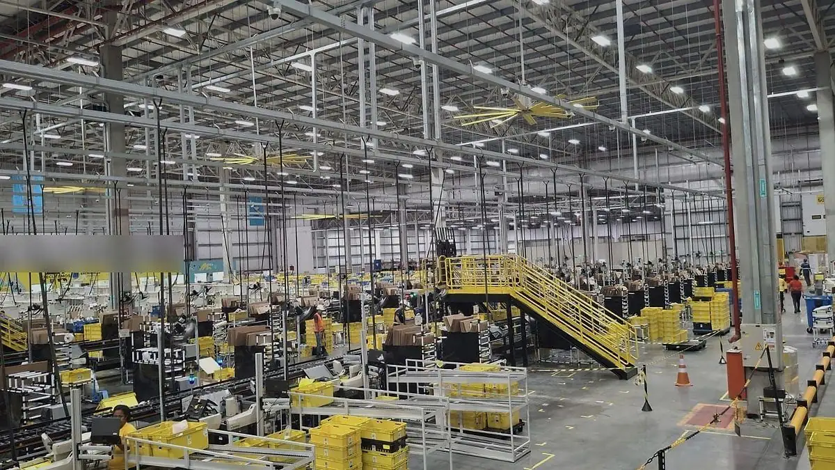 Vista ampla de centro de distribuição em operação, com plataformas, esteiras e estrutura metálica do galpão